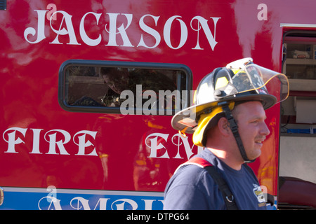 Focus su EMT all'interno di Jackson Wisconsin ambulanza aiutare un paziente con un vigile del fuoco al di fuori Foto Stock