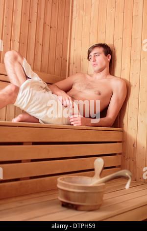 Giovane uomo di rilassarvi nella sauna Foto Stock