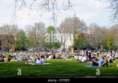 Una folla di gente che godendo il sole sui campi di Highbury, London Borough di Islington, England Regno Unito Foto Stock