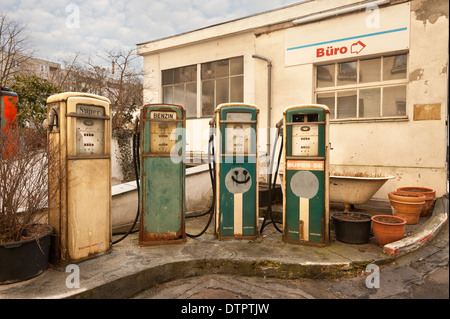 In vecchio stile benzina diesel benzina pompa carburante dispenser design retrò abbandonati su un vecchio garage in disuso e il piazzale antistante Foto Stock