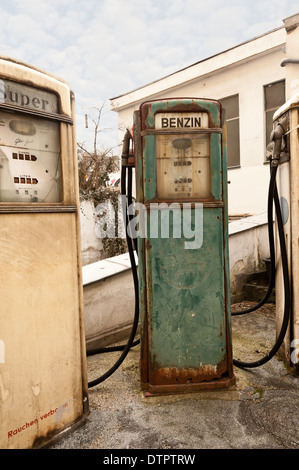 In vecchio stile benzina diesel benzina pompa carburante dispenser design retrò abbandonati su un vecchio garage in disuso e il piazzale antistante Foto Stock