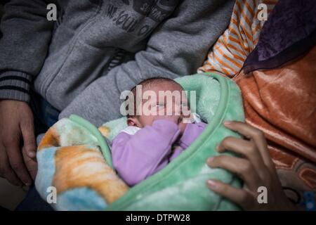 Il Cairo, Egitto. Il 22 febbraio, 2014. Un neonato si trova tra le braccia della madre in un reparto di el-Galaa maternità ospedale di insegnamento al Cairo, capitale dell Egitto, il 22 febbraio, 2014. In Egitto la popolazione ha raggiunto 94 milioni, secondo la più recente dichiarazione rilasciata il 20 febbraio dal paese agenzia centrale per il pubblico di mobilitazione e di statistiche. © Pan Chaoyue/Xinhua/Alamy Live News Foto Stock