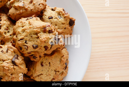 Primo piano di fresco con scaglie di cioccolato e noci pecan cookie su una piastra bianca - con copyspace Foto Stock