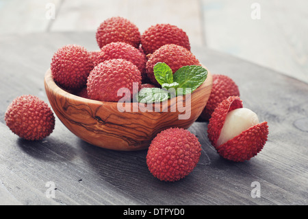 Litchi freschi in un recipiente su un sfondo di legno Foto Stock