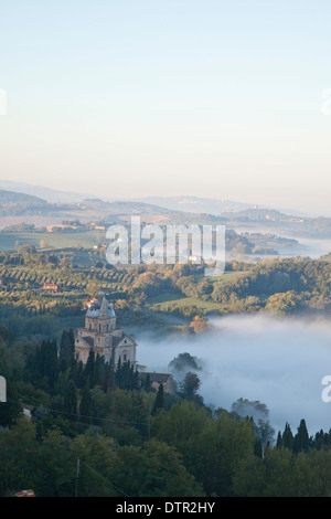 Nebbia di mattina e la luce del sole su San Biagio e le piste al di sotto di Montepulciano, Toscana, Italia. Credito Jo Whitworth Foto Stock