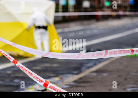 Belfast, Irlanda del Nord, 23 Febbraio 2014 - Polizia nastro forma un cordone intorno a una scena del crimine, come è esaminato dalla scena del crimine ufficiali vestito di bianco caldaia tute e utilizzando un esame tenda Credit: stephen Barnes/Alamy Live News Foto Stock