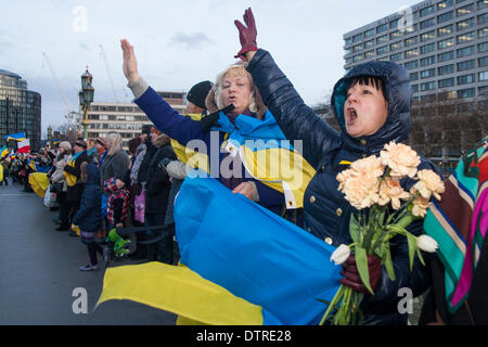 Londra, Regno Unito. 23 feb 2014. Centinaia di ucraini formata una catena umana sul Westminster Bridge per celebrare il distacco dal potere del regime Yanukovych, e a piangere i punteggi uccisi durante la rivolta di Kiev nella settimana precedente. Credito: Paolo Davey/Alamy Live News Foto Stock