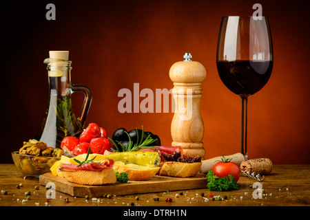 Ancora in vita con gourmet spuntini mediterranei e un bicchiere di vino rosso Foto Stock