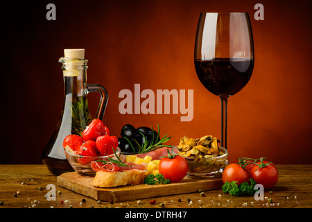 Ancora vita con le tradizionali tapas e snack e un bicchiere di vino rosso Foto Stock