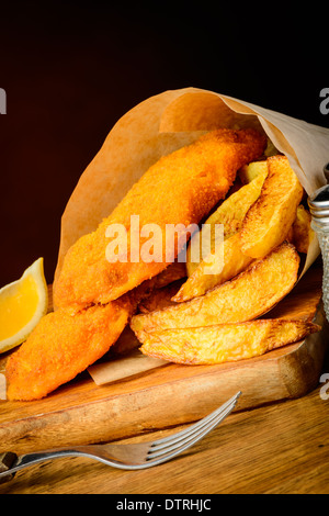 Il tradizionale pesce e patatine pasto avvolto nella carta Foto Stock