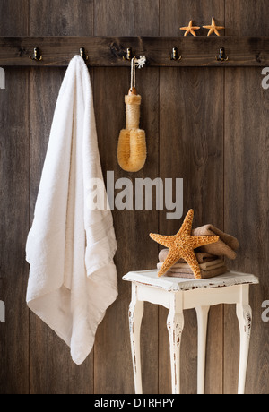 Bagno interno con appeso asciugamano bianco e stelle marine Foto Stock