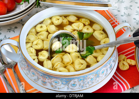 Ciotola con brodo di manzo caldo e tortellini italiano Foto Stock