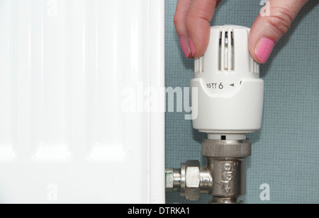 Donna termostatico di tornitura/radiatore valvola/su/giù sul sistema centrale di riscaldamento domestico di casa, England, Regno Unito Foto Stock