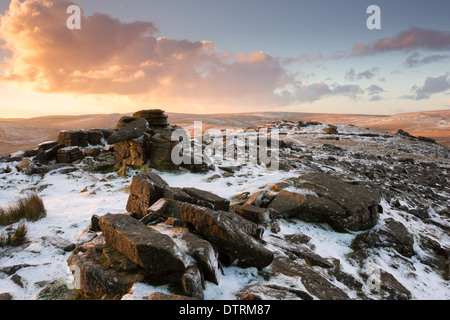 Una leggera spolverata di neve sul Belstone tor a sunrise parco nazionale di Dartmoor Devon UK Foto Stock