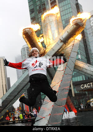 Vancouver, Canada. 23 feb 2014. Una donna salta in aria durante le celebrazioni del Canada è successo a Sochi Olimpiadi, febbraio 23, 2014 a Vancouver in Canada. Il Vancouver calderone olimpico fu relit nel febbraio 23, 2014, per celebrare il Canada è successo a Sochi 2014 Giochi Olimpici. Credito: Sergei Bachlakov/Xinhua/Alamy Live News Foto Stock