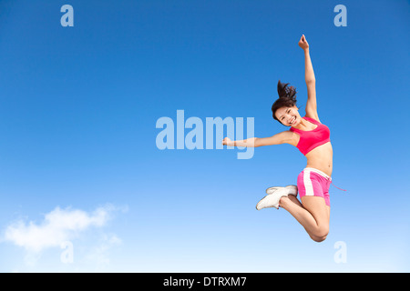 Felice asian giovane donna jumping nel cielo Foto Stock