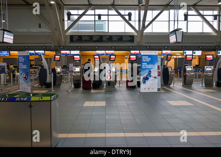 I passeggeri con bagagli utilizzando l'Air Canada controllare nei chioschi terminali nel lato internazionale dell'Aeroporto Internazionale di Vancouver YVR. Foto Stock