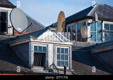 Antenne paraboliche piatto sul vecchio edificio tetto Foto Stock