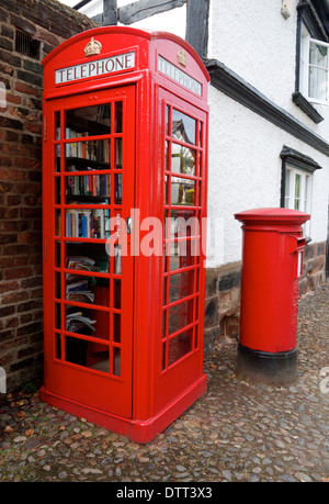 Il vecchio telefono rosso scatola essendo utilizzato come una biblioteca pubblica Foto Stock