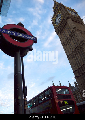 La stazione della metropolitana di firmare con il Big Ben e un bus rosso in background Foto Stock