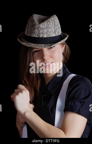 Ragazza con bretelle e uomo di hat su sfondo nero Foto Stock