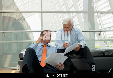 Imprenditori caucasica parlando in area lobby Foto Stock