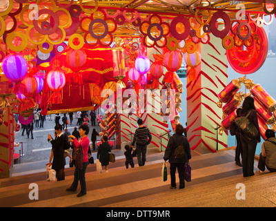 La gente a piedi e scattare foto su passaggi lungo Kowloon Waterfront, Hong Kong al nuovo anno cinese con grandi decorazioni colorate Foto Stock