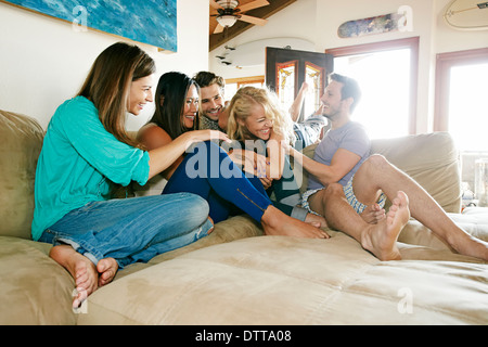 Gli amici rilassandosi insieme sul divano Foto Stock