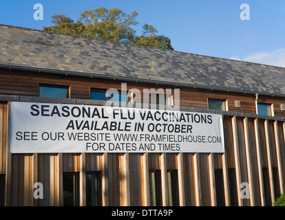 L'influenza stagionale vaccinazioni disponibile segno poster su Framfield centro salute, Woodbridge, Suffolk, Inghilterra Foto Stock