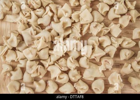 Vista dei fatti in casa ravioli grezzo su una tavola di legno sfondo Foto Stock