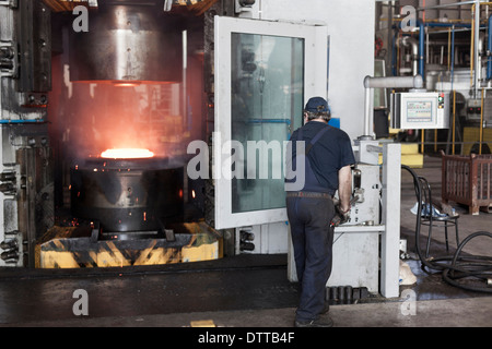 Lavoratore caucasica operanti in acciaio macchine di fusione in fabbrica Foto Stock