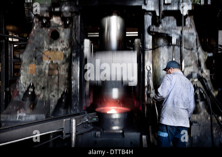 Lavoratore caucasica operanti in acciaio macchine di fusione in fabbrica Foto Stock