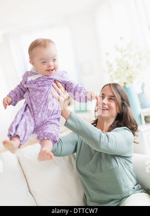 Madre caucasica giocando con il bambino con la sindrome di Down Foto Stock