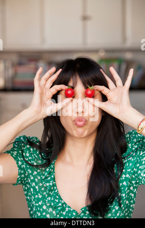 Donna che gioca con i pomodori Foto Stock