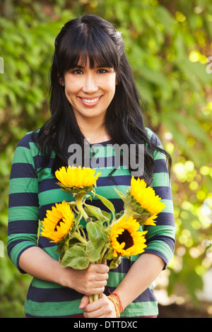 Donna che mantiene bouquet di girasoli Foto Stock