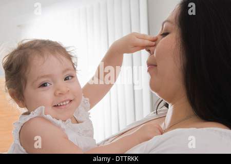 Ispanico bambina di toccare la madre del naso Foto Stock