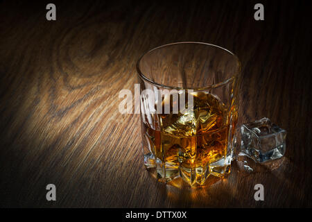 Il whiskey con ghiaccio in vetro su legno Foto Stock