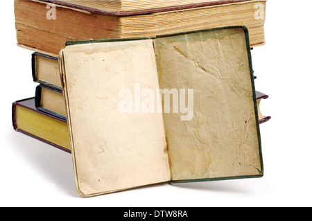 Pila di libri vecchi e uno aperto su sfondo bianco Foto Stock