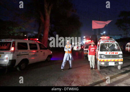 Recues funzionari di polizia e di raccogliere al sito dopo il suicidio esplosione di bomba vicino alla frontiera Corps (FC) verificare post vicino al Consolato Iraniano all'Università Road a Peshawar lunedì 24 febbraio, 2014. Un suicidio blast targeting di un corpo di frontiera (FC) checkpost vicino al Consolato Iraniano Università su strada a sinistra due funzionari FC morti e nove feriti. SP Ahsanullah ha confermato che l'esplosione fosse suicida in natura e ha affermato che dopo il bombardiere era stato impedito di entrare il checkpost in sua automobile. Foto Stock