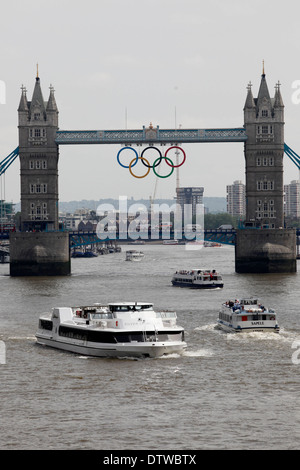 Giant set di anelli olimpici vengono visualizzati dal Tower Bridge a giugno 27, 2012 a Londra, Inghilterra. Gli anelli pesare oltre tre tonnellate e misura oltre 25 metri di larghezza da 11,5 metri di altezza; essi saranno illuminate in una luce di mostrare ogni sera durante i giochi. Foto Stock