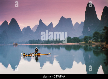 La Cina, nel Guangxi, il fiume Li, cormorano la pesca al tramonto. Foto Stock