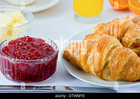 La prima colazione continentale con croissant, marmellata, succo di arancia, burro e succo di arancia. Foto Stock
