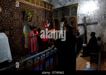 I cristiani ortodossi etiopi che pregano all'interno della Cappella Copta di San Michele Arcangelo nella parte inferiore del monastero etiope di Deir El-Sultan, che si trova sul tetto della Chiesa del Santo Sepolcro nella città vecchia di Gerusalemme Est Israele Foto Stock