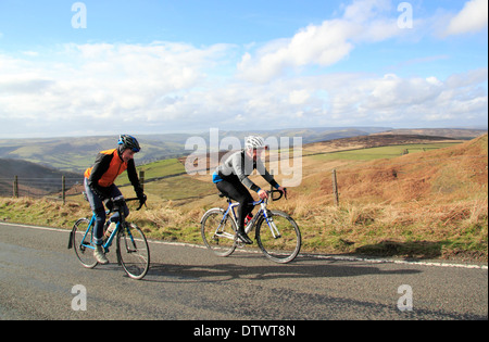 I ciclisti maschio ride fino Ringinglow Road vicino a Sheffield & Hathersage nel Parco Nazionale di Peak District, Derbyshire, England, Regno Unito Foto Stock