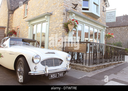 Classic Austin Healey auto al di fuori di un negozio tradizionale nel villaggio di Wedmore nel Somerset, Regno Unito 2013 Foto Stock