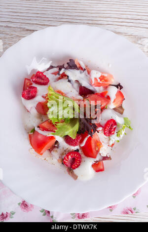 Insalata con dressing e lamponi freschi Foto Stock