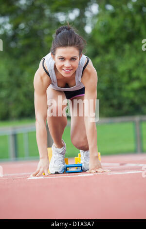 Atleta femminile in blocchi di partenza Foto Stock