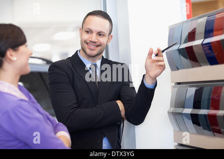 Venditore che mostra una tavolozza di colori per una donna Foto Stock