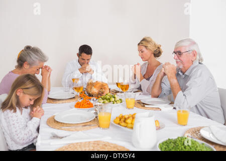 Famiglia dire grazia prima di mangiare una Turchia Foto Stock