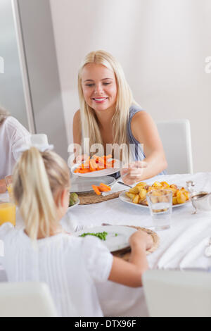 Madre di consegnare le carote per figlia a cena Foto Stock